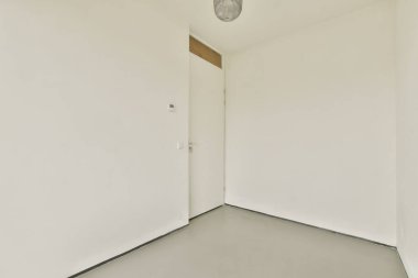 Basit, minimalist bir oda düz beyaz duvarlar, bir kapı ve tavan lambası sergiliyor, açık ve havadar bir his yaratıyor, modern tasarımlar için mükemmel..