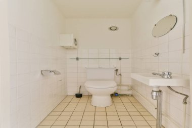 Pürüzsüz ve temiz minimalist banyo tasarımı beyaz bir tuvalet, fayanslı zemin ve basit eşyalar sergiliyor. Çağdaş içsel ilham için ideal.