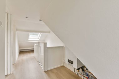 Minimalist tasarım elementleri, nötr tonlar ve tavan penceresinden gelen doğal ışık içeren parlak ve modern bir iç mekan koridoru havadar bir his yaratıyor..