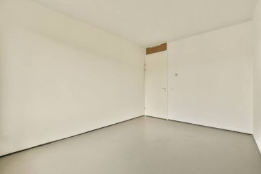 Minimalist tasarımı ve nötr renk paletiyle karakterize edilmiş el değmemiş, boş bir oda, düz duvarları ve uzayı vurgulayan basit bir düzeniyle..
