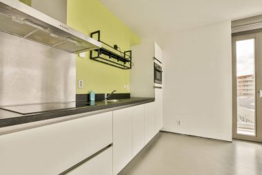Pürüzsüz ve çağdaş bir mutfak. Minimalist bir düzen, temiz çizgiler ve açık, havadar bir ortam yaratan dağınık yüzeyler..