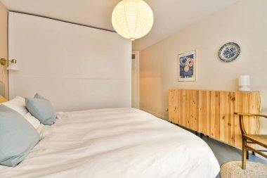 Yumuşak renkleri, minimalist mobilyaları ve sıcak ışıklandırması olan sakin ve davetkar modern bir yatak odası. Rahatlamak ve rahatlamak için mükemmel..