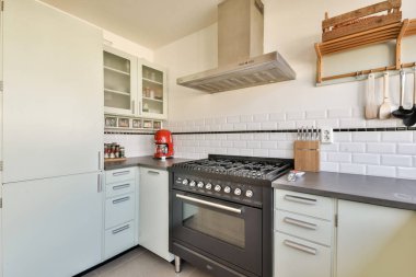 Dolaplar, tezgahlar ve aletlerin uyumlu bir karışımından oluşan şık, modern bir mutfak mutfak, mutfak etkinlikleri için davet edici bir alan yaratıyor..