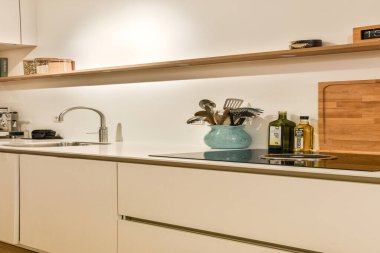 Gösterişli ve çağdaş mutfak, minimalist dolaplar, şık aletler ve temiz bir tezgah düzeneği. Modern ev estetiği için ideal..