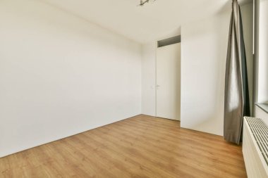 Boş duvarları ve zemini olan modern, minimalist bir iç mekan, tasarımda basitliği vurgulayan, pencereden süzülen doğal ışık..
