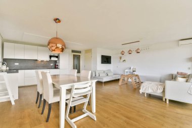 Şık bir yaşam alanı ve temiz, minimalist bir tasarımı ve ahşap döşemesi olan zarif bir mutfağı olan çağdaş bir alan..