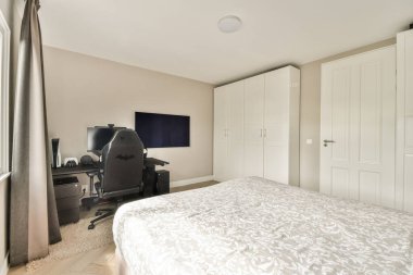 Zarif, modern bir yatak odası. Rahat bir yatağı, ofis düzeneği ve geniş bir deposu var. Yumuşak renk paleti sükuneti arttırır.