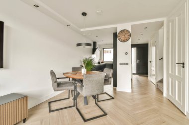 Bu resim şık ve minimalist bir iç tasarım sergiliyor. Gösterişli mobilyalar, yumuşak ışıklandırma ve odaları ferah hissettiren açık bir düzen içeriyor..
