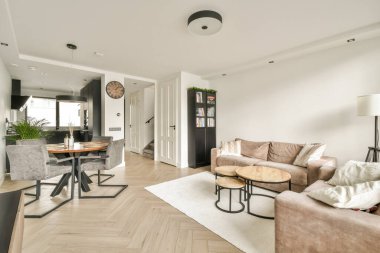 Minimum mobilya, ahşap döşeme ve rahat bir atmosfer için karanlık ve aydınlık elementlerin karışımından oluşan şık bir modern oturma odası..