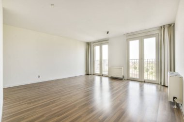 Ahşap döşeme, geniş pencereler ve sakin bir yaşam ortamı için basit, düzensiz bir tasarım içeren parlak ve ferah bir daire..