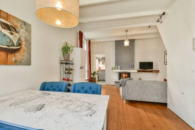 Modern mobilyaların, sıcak ışığın ve rahatlık ve estetiğin karışımının bulunduğu şık ve davetkar bir oturma odası. Rahatlamak ve sosyalleşmek için mükemmel..