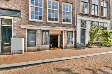 Şehir ortamında geniş pencereler ve eşsiz mimari tasarım sergileyen modern bir binanın güzel bir manzarası. Davetiye girişi hareketli bir alana açılıyor..