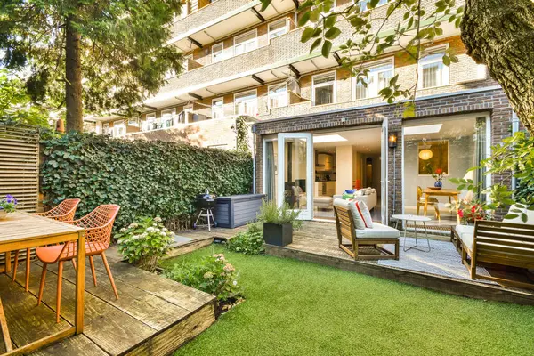 Konforlu koltukları ve canlı yeşillikleri olan çağdaş bir bahçe. Şehir ortamında rahatlamak için mükemmel. Şık tasarım konfor ve estetik cazibeyi vurgular.