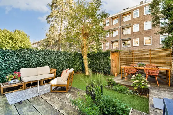 Rahat koltuklar, canlı yeşillikler ve rahatlama ve toplanma için ideal dekorasyon içeren güzel düzenlenmiş bir bahçe alanı..