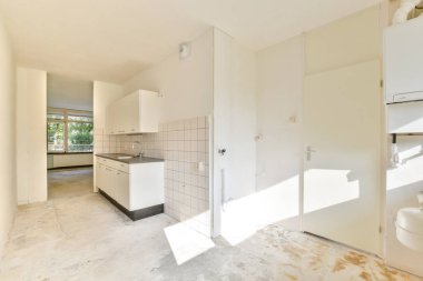 Minimalist tasarım elementleri, gösterişli dolaplar ve geniş pencerelerden bol miktarda doğal ışık barındıran parlak ve havadar bir modern mutfak..