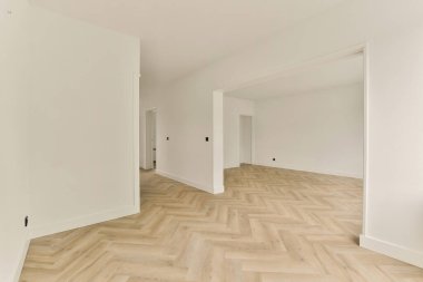 Geniş, modern iç mekan. Açık renkli duvarlar ve şık ringa kemiği desenli döşemeler. Çağdaş ve davetkar bir atmosfer yaratıyor..