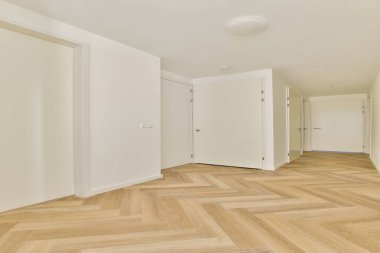 Geniş, aydınlık, modern bir koridor şık ahşap ringa kemiği döşemeleri ve minimalist beyaz kapılar, davetkar bir atmosfer yaratıyor..