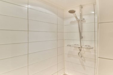 Zarif fayanslar ve banyo yenileme için ideal çağdaş bir banyo armatürü içeren modern bir duş tezgahının temiz ve minimal tasarımı..