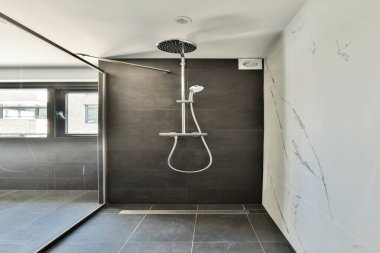 Çağdaş duş alanı gösterişli hatlar, sağanak yağmur başlığı ve zarif fayanslar içeriyor. Minimalist estetik odaları geniş hissettiriyor..