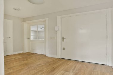 Ahşap döşemeleri ve temiz çizgileri olan, davetkar ve ferah bir atmosfer yaratan çağdaş bir iç mekan koridoru..