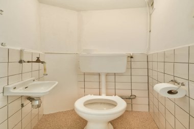 Tuvaleti, lavabosu ve fayanslı duvarları olan küçük ve minimalist bir tuvalet. Tasarım işlevselliği ve temizliği vurguluyor..