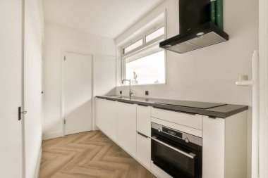 Şık, gösterişli bir mutfak, entegre bir fırın ve geniş doğal ışık ve çağdaş his barındıran minimalist bir tasarım..