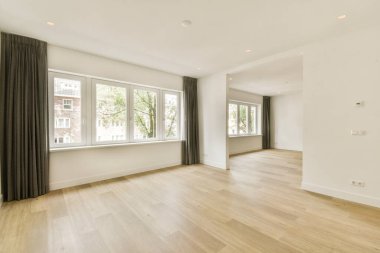 Geniş pencereli, minimalist dizaynlı ve doğal ahşap döşemeli parlak ve havadar bir yaşam alanı. Modern bir evde rahat bir ortam yaratmak için ideal..