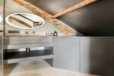Gösterişli modern banyo, içinde taş bir lavabo, tavanda ahşap kirişler ve şık dekoratif elementler var. Çağdaş tasarım ve kırsal cazibenin mükemmel bir karışımı..