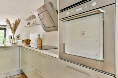 Gösterişli dolaplar, entegre aletler ve çağdaş yaşam için mükemmel temiz estetik içeren modern bir mutfak..