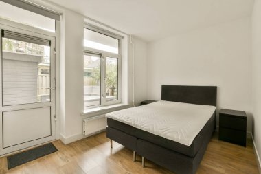 Pürüzsüz ve minimalist bir yatak odası. Çift kişilik bir yatak odası. Geniş pencereler, doğal ışığa izin veriyor..
