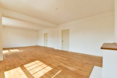 Ahşap döşemeleri ve dekorasyona hazır minimalist duvarları olan güneşli, ferah bir oda. Çeşitli iç tasarım ve düzenlemeler için ideal.