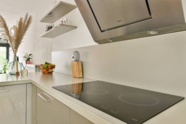 Minimalist tasarım elementleri, zarif bir tezgah ve doğal dekor aksanlarıyla donatılmış, işlevselliği ve stili arttıran şık modern bir mutfak..