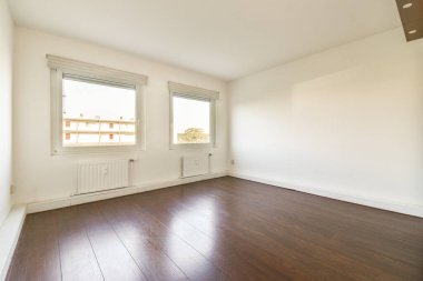 Ahşap döşeme ve geniş pencerelerin yer aldığı iyi ışıklandırılmış ve ferah minimalist bir iç mekan, sakin bir atmosfer ve doğal ışık akışı sunuyor..