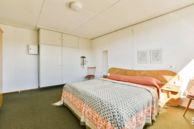 Rahat bir yatak odası, sanatsal duvar dekorasyonu ve minimalist mobilyaları olan parlak ve davetkar bir yatak odası. Rahatlamak ve gevşemek için ideal..