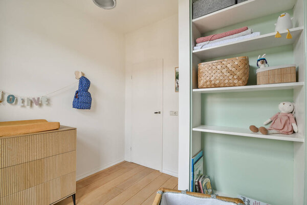 Благоустроенная детская комната с игривым декором, кладовыми решениями и веселой атмосферой, идеально подходящей для воспитания креативности и комфорта.