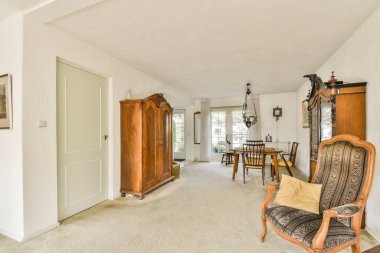 Klasik ahşap mobilyalar, yumuşak renkler ve geniş bir yerleşim yeri rahatlama ve sohbet içerikli iyi döşenmiş bir iç mekan..