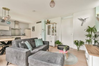 Şık mobilyaların, dekoratif bitkilerin ve parlak bir atmosferin olduğu çağdaş bir oturma odası. Rahatlama ve sosyal toplantılar için ideal..