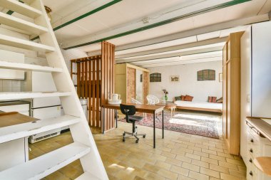 Parlak ve havadar bir iç mekan, ahşap aksanlı minimalist dekor, işlevsel bir çalışma alanı ve rahatlama veya üretkenlik için rahat oturma alanları.