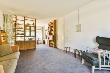 Şık mobilyaların ve doğal ışık ve zarif dekor aksanlarıyla tamamlanmış sıcak renk paletinin yer aldığı geniş bir oturma odası..