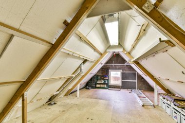 A çerçeveli, ahşap kirişler ve minimalist dekorların sergilendiği modern bir kulübe manzarası. Mekan iyi aydınlatılmış, davetkar bir atmosfer yaratıyor..