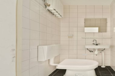Bu resim, modern demirbaşların, temiz çizgilerin ve basitliği artıran nötr renk paletinin yer aldığı gösterişli ve minimalist bir banyo tasarımı sergiliyor..