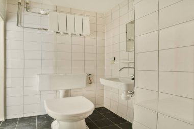 Gösterişli ve çağdaş banyo fayanslı duvarlar, minimalist eşyalar ve modern estetik için verimli bir alan kullanımı. Küçük yaşam alanları için ideal.