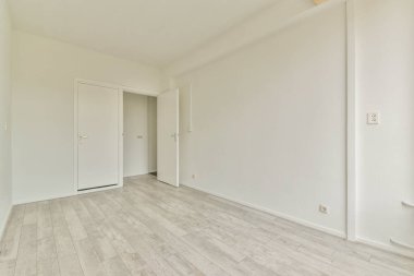 Geniş, minimalist bir iç mekan. Açık renkli duvarları ve ahşap zemini olan boş bir oda. Modern tasarım kavramlarını sergilemek için ideal..