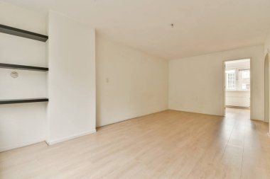 Geniş, boş bir oda. Açık ahşap döşeme ve beyaz duvarlar var. Temiz ve minimalist bir estetik yaratıyor. İç tasarım ilham kaynağı için ideal.