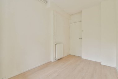 Sade beyaz duvarlar, ahşap döşemeler, sadelik ve sükunet içeren ferah, minimalist bir oda. Modern yaşam kavramları için ideal.