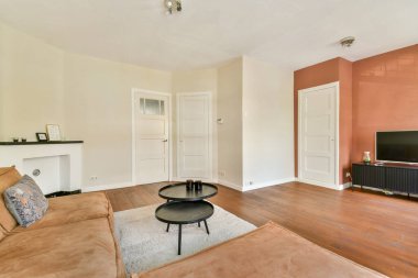 Rahat ve sofistike olması için tasarlanmış rahat bir kanepe, sanatsal dekor ve zarif döşemeleri olan geniş, modern bir oturma odası..