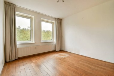 Doğal ışığın ahşap zemini aydınlatmasına izin veren ve sakin ve minimalist bir atmosfer yaratan boş bir oda..