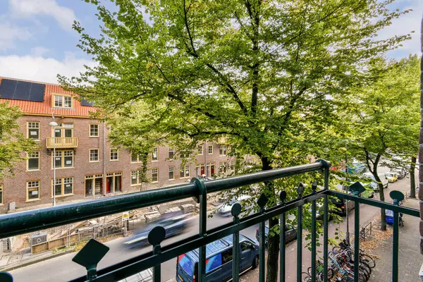 Canlı bir şehir manzarası, renkli binaların ve park edilmiş bisikletlerin zemininde yemyeşil ağaçlar sergileniyor. Güneşli bir gün cazibemi artırır.