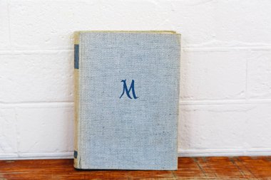 Siyah bir kurye çantasının kenarı, fermuar çekme ve kayış detaylarını gösteriyor, fermuarın yanında da küçük bir turuncu şerit var. Bu karede çantalar parlak, minimalist tasarım vurgulanmış.