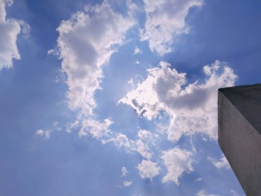 Mavi gökyüzündeki sislerin arasından güneş ışığı. Mavi bir gökyüzünde bulutlardan fışkıran güneş ışığı ya da ışınlar. Ruhani dini altyapı.